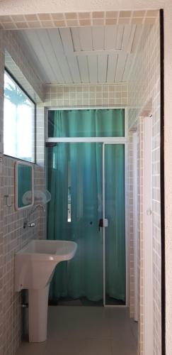un bagno con doccia in vetro e lavandino di Lindo Sobrado com Piscina em Condomínio Fechado a Bertioga