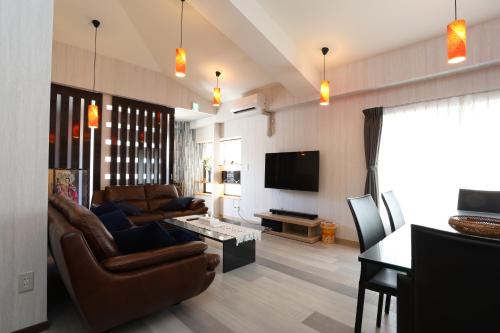 a living room with a couch and a table and a tv at Oyado Tsuki to Kawa in Tokyo