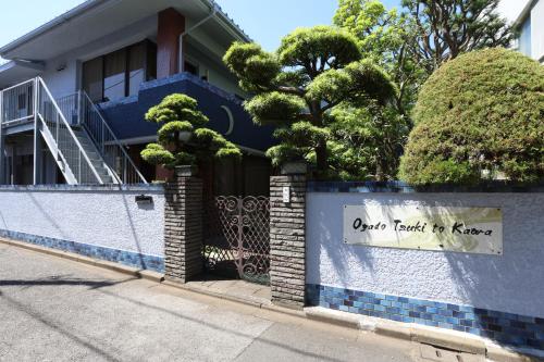a blue house with a fence with a sign on it at Oyado Tsuki to Kawa in Tokyo