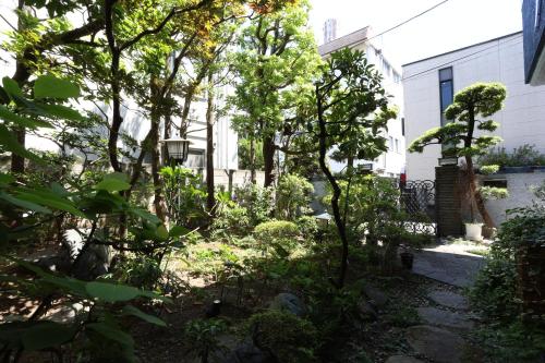 a garden in front of a house with trees at Oyado Tsuki to Kawa in Tokyo