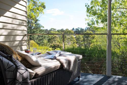 a porch with a couch and a large window at Provence Spa Villa 2 in Hepburn Springs