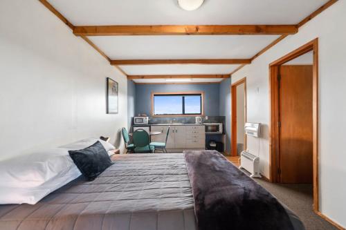 a bedroom with a large bed and a desk at Mountain Heights Lodge in National Park