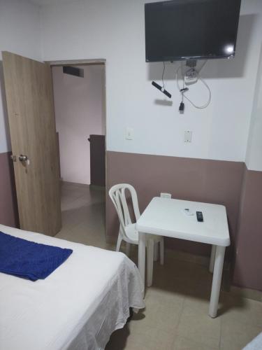 een kamer met een bed, een tafel en een tv bij HOTEL MANANTIAL 1 in Playa Dormida