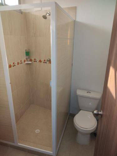 a bathroom with a toilet and a shower stall at HOTEL MANANTIAL 1 in Playa Dormida