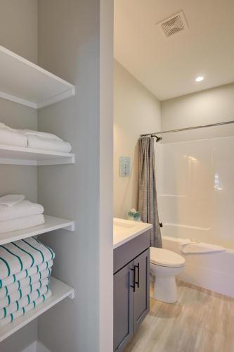 a white bathroom with a toilet and a sink at Amongst The Waves in Ocean Shores