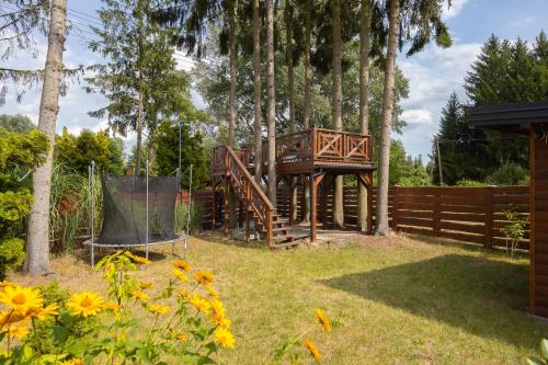 a wooden bridge in a yard with trees at DOMEK CZAS NA CUPEL - Apartament na 5 in Serock