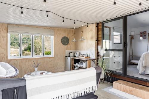 ein Wohnzimmer mit einem Sofa und einem Spiegel in der Unterkunft Flaxpod Cabin in Raglan