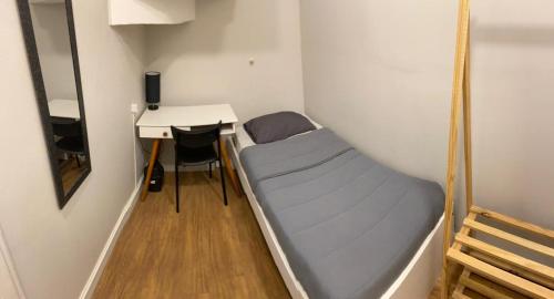 a small room with a bed and a desk at Gup Hostel in Curitiba