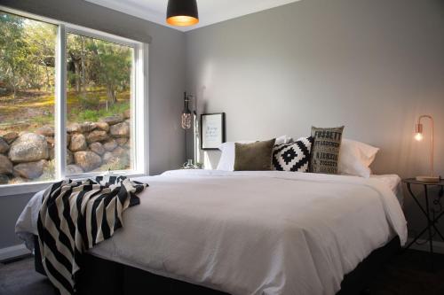 a bedroom with a large bed with a window at Quartz Retreat in Daylesford
