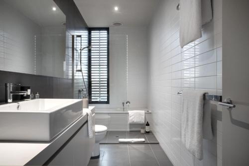 a white bathroom with a sink and a toilet at Ridge House in Hepburn Springs