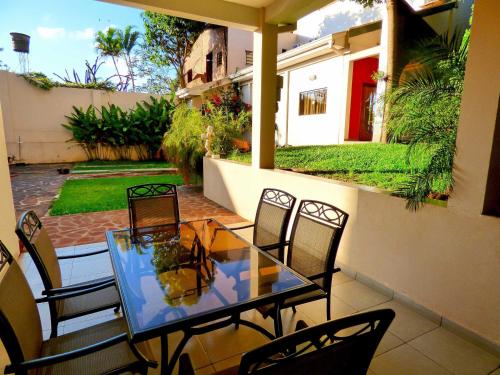 a glass table and chairs on a patio at De La Costa Hotel in Encarnación