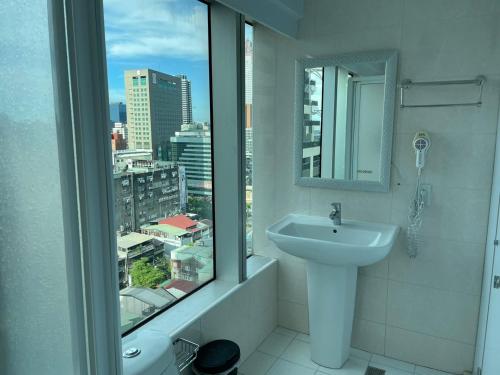 uma casa de banho com um lavatório e uma janela com uma cidade em 西門雲町旅店 Sky Gate Hotel em Taipei