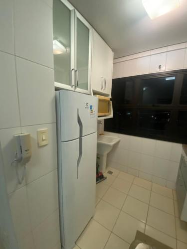 a kitchen with a refrigerator and a sink at Flat muito bem localizado in Palmas