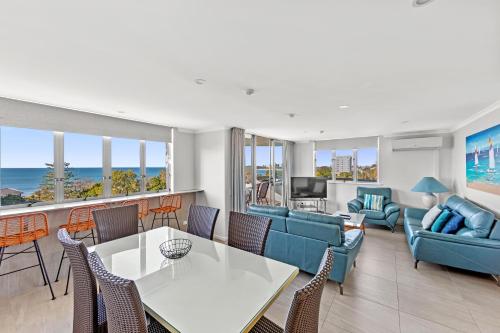 a living room with a table and chairs at Newport Mooloolaba Apartments in Mooloolaba