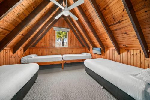 Duas camas num quarto com tectos em madeira em ULTIQA Village Resort em Port Macquarie