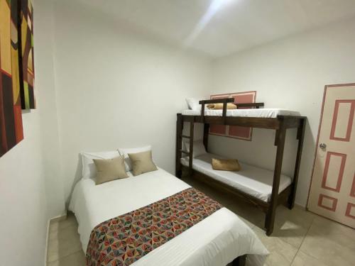 ein Schlafzimmer mit einem Bett und einem Etagenbett in der Unterkunft Mahalo Hostel in Salento