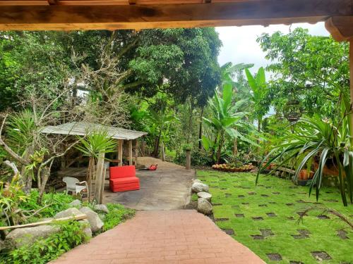 a garden with a red chair and a gazebo at Hotel Campestre Villa Nico in Bochalema