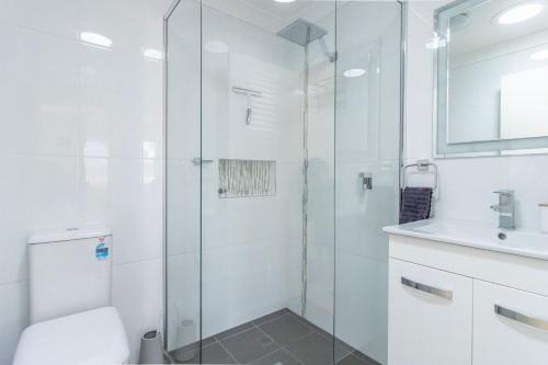 a bathroom with a shower and a toilet and a sink at The Perfect Holiday Home in Sussex inlet