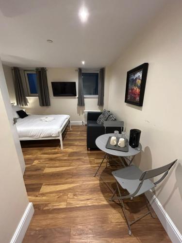 una pequeña sala de estar con cama y mesa. en Modern Double Room with Sofa, en Edimburgo