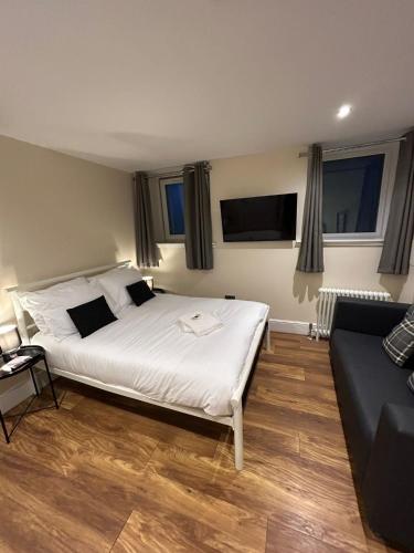 1 dormitorio con 1 cama blanca grande y 1 sofá en Modern Double Room with Sofa, en Edimburgo