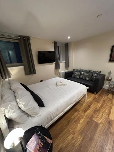 1 dormitorio con 1 cama blanca grande y 1 sofá en Modern Double Room with Sofa, en Edimburgo