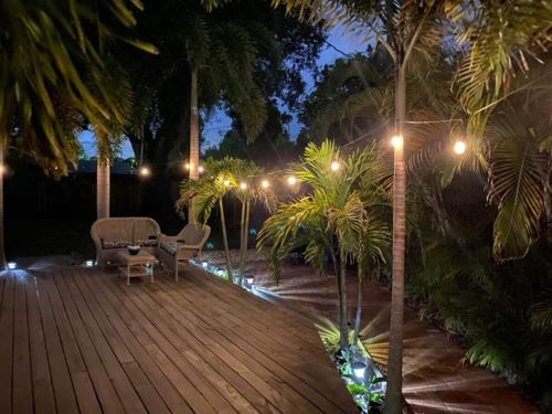 a wooden deck with chairs and palm trees at night at BCC Country Club in Bradenton