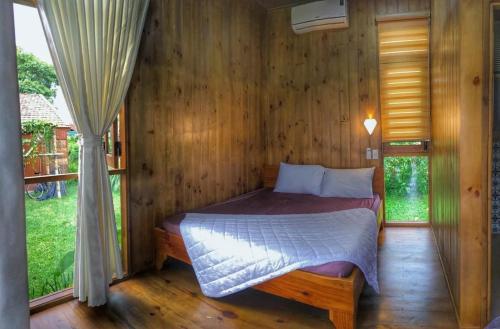 a bedroom with a bed in a wooden room at DuGiang Homestay in Buon Ma Thuot