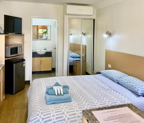 a bedroom with a bed with a towel on it at Econo Lodge Karratha in Karratha