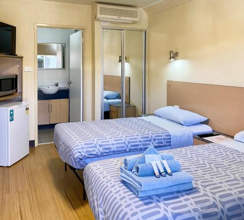 a hotel room with two beds with towels on them at Econo Lodge Karratha in Karratha