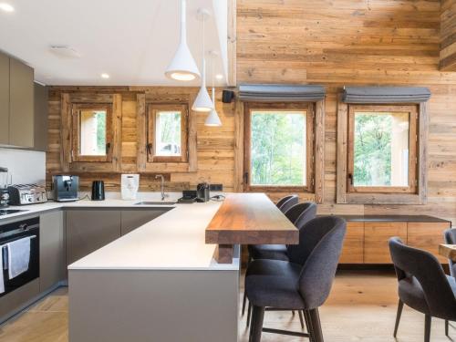 - une cuisine avec des murs en bois, une table et des chaises dans l'établissement Chalet luxe 15 pers avec sauna et jacuzzi aux 3 Vallées - FR-1-570-32, à Saint-Martin-de-Belleville