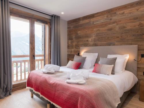 une chambre avec un grand lit avec des serviettes dessus dans l'établissement Chalet luxe 15 pers avec sauna et jacuzzi aux 3 Vallées - FR-1-570-32, à Saint-Martin-de-Belleville