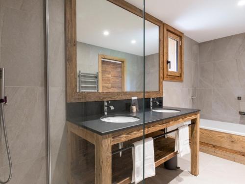 une salle de bain avec deux lavabos et un miroir dans l'établissement Chalet luxe 15 pers avec sauna et jacuzzi aux 3 Vallées - FR-1-570-32, à Saint-Martin-de-Belleville