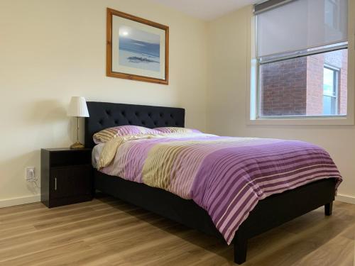 1 dormitorio con 1 cama con manta morada y ventana en Royal Lodge - A Luxury Lifestyle en Melbourne
