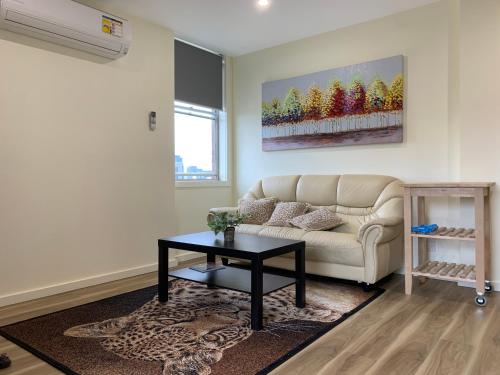 a living room with a couch and a table at Royal Lodge - A Luxury Lifestyle in Melbourne