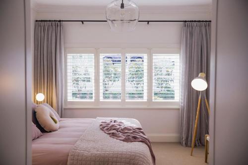 a bedroom with a bed and two windows at Sandringham in Daylesford