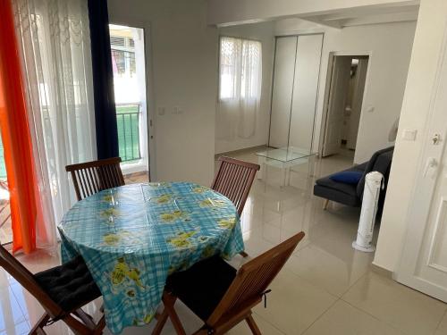 einen Tisch und Stühle im Wohnzimmer mit einem Tisch in der Unterkunft Duplex centre-ville in Le Moule