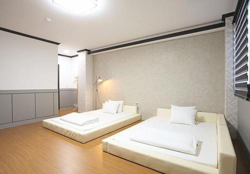 Habitación amplia con 2 camas y sábanas blancas. en CF Pension en Pohang