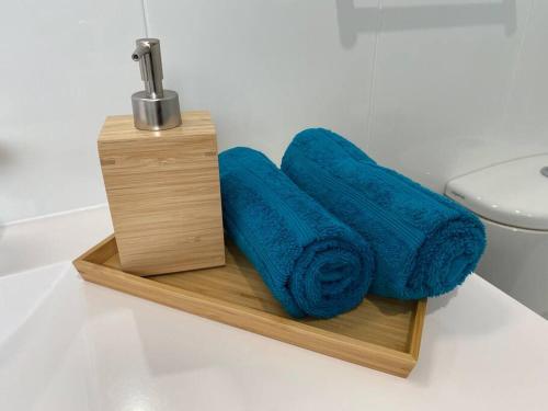 a wooden holder with blue towels and a sink at Mountain Views (3 min drive to beach) in Gerringong