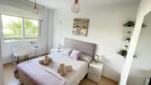 a bedroom with a bed with two towels on it at Apartamento en Resort De Golf in Torre-Pacheco