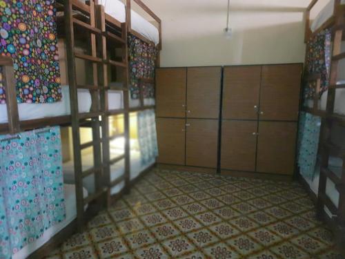 a room with bunk beds and cabinets and a floor at Guaya Hostel in Mérida