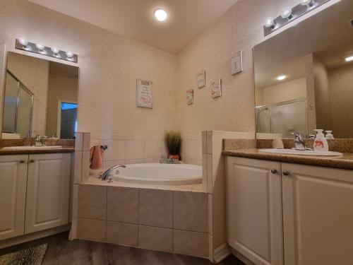 a bathroom with two sinks and a bath tub at Greenlinks 923 at Lely Resort - Luxury 2 Bedrooms & Den Condo in Naples