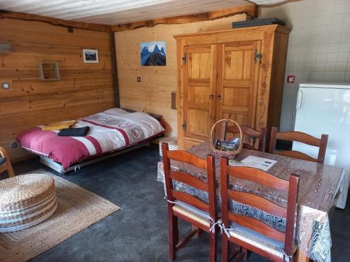 a bedroom with a bed and a table and chairs at Studio l'Étoile in Saint-Jean-dʼArves