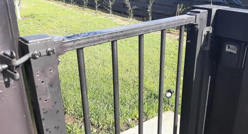 a metal railing next to a field of grass at The Poolhouse in Matamata