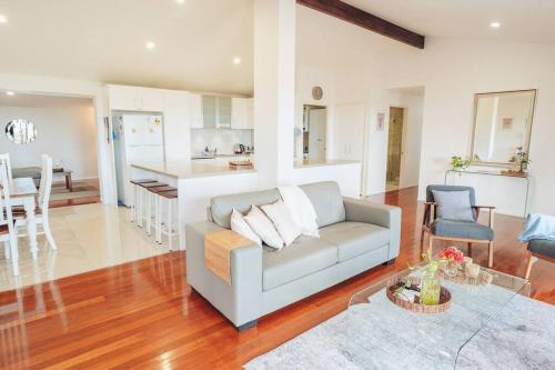 a living room with a couch and a kitchen at Stunning Home in Mt Mellum with Panoramic Coastal Views in Bald Knob