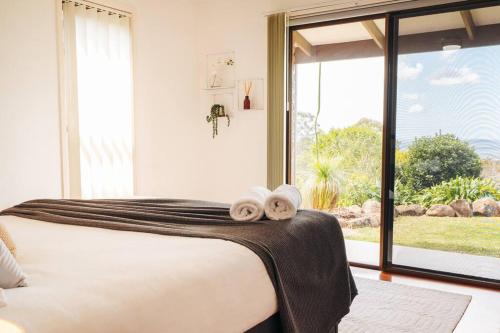 a bedroom with a bed and a large window at Stunning Home in Mt Mellum with Panoramic Coastal Views in Bald Knob