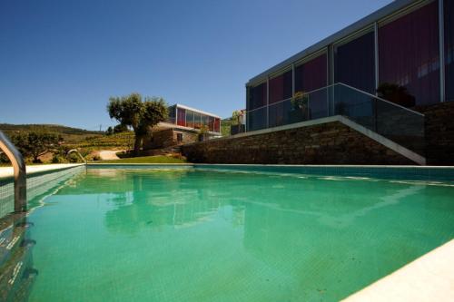 a swimming pool with green water in front of a building at Casa Da Quinta De Vale D' Arados in Mesão Frio
