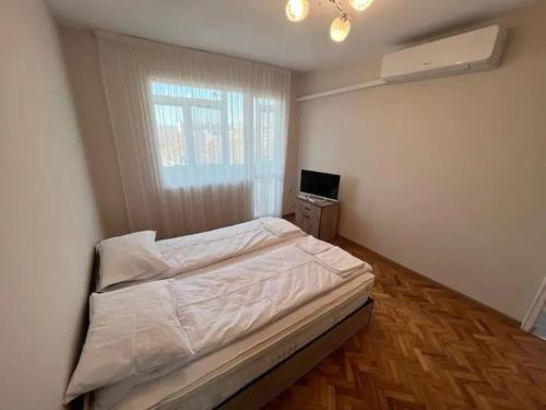 Schlafzimmer mit einem Bett und einem Schreibtisch mit einem Computer in der Unterkunft Апартамент ОНИКС in Warna