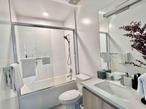 a white bathroom with a toilet and a sink at New Designer Corner Penthouse 2 Bedroom w/ 3 Beds in Los Angeles
