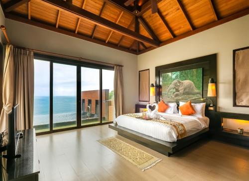 Un dormitorio con una cama con vista al mar. en Ayara Kamala Resort & Spa - SHA Extra Plus, en Kamala Beach