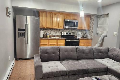 a living room with a couch and a kitchen at Cozy King Bed, Free Parking! in Newark